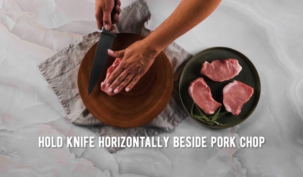 Step 1 to butterflying a pork chop - hold knife horizontal Step 1 to butterflying a pork chop - hold knife horizontal